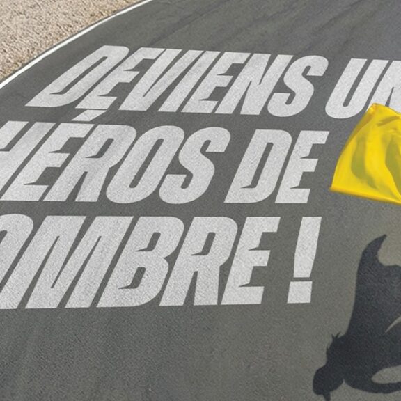 Commissaire de piste avec drapeau jaune sur circuit mettant en avant le rôle des héros de l’ombre en sport moto