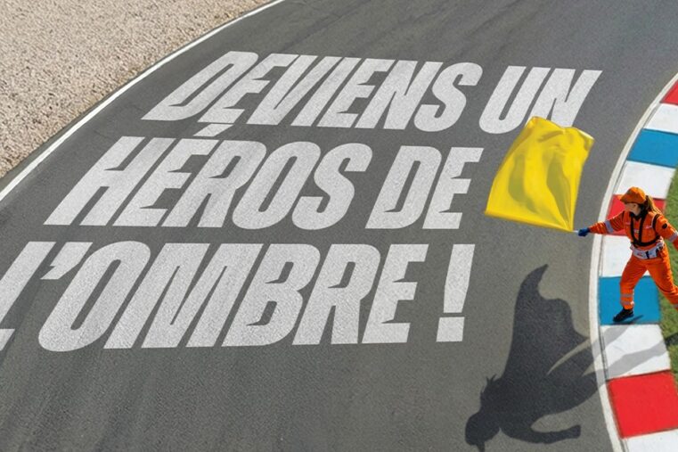 Commissaire de piste avec drapeau jaune sur circuit mettant en avant le rôle des héros de l’ombre en sport moto
