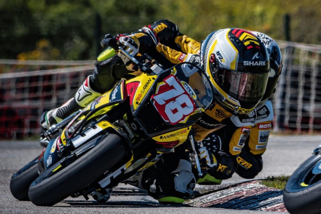 Jeune pilote KF78 en action sur circuit avec le logo MotoGP26 visible sur la moto